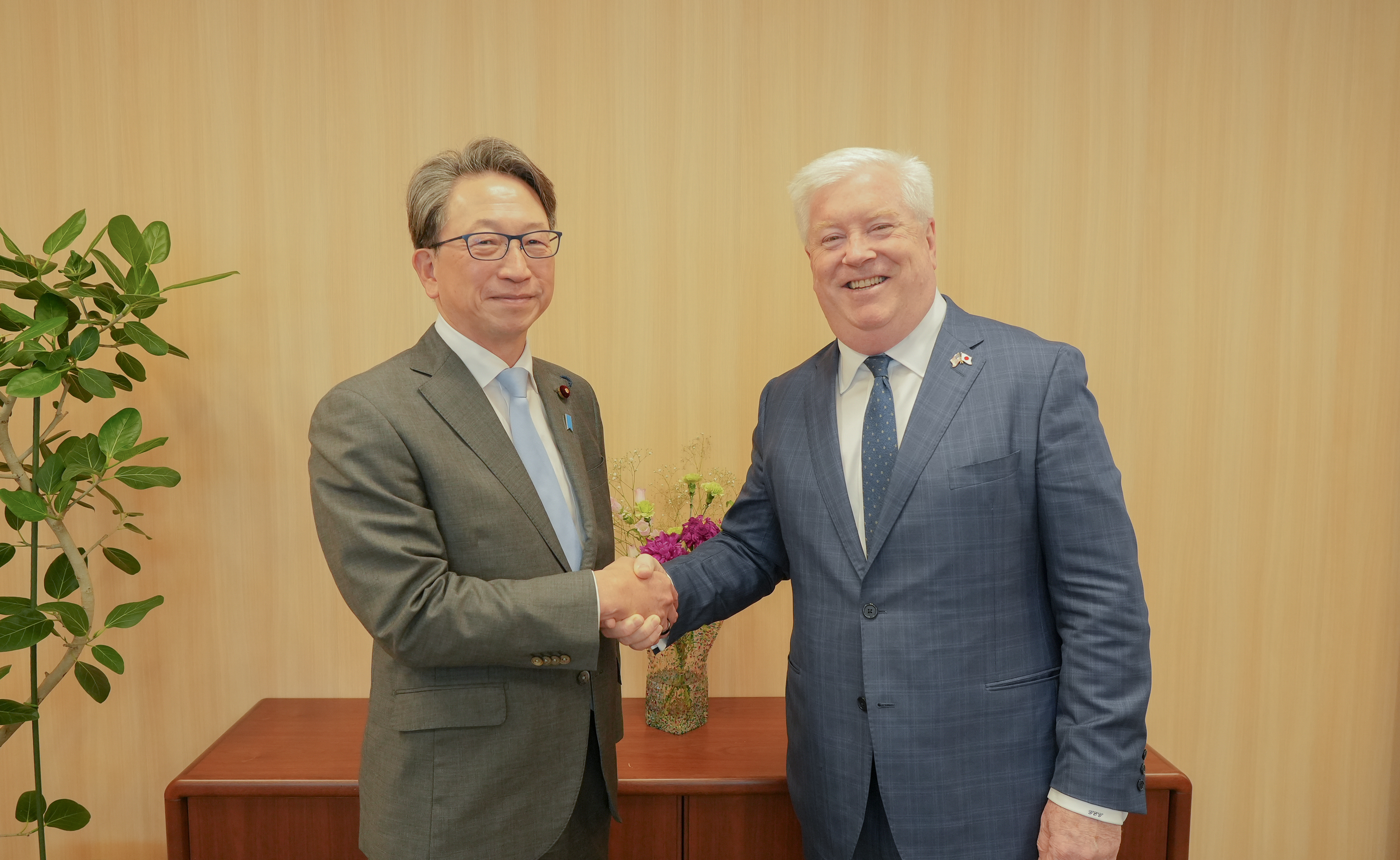 Photo of Digital Minister Taira on the left, shaking hands with Ambassador-Designate George Glass.