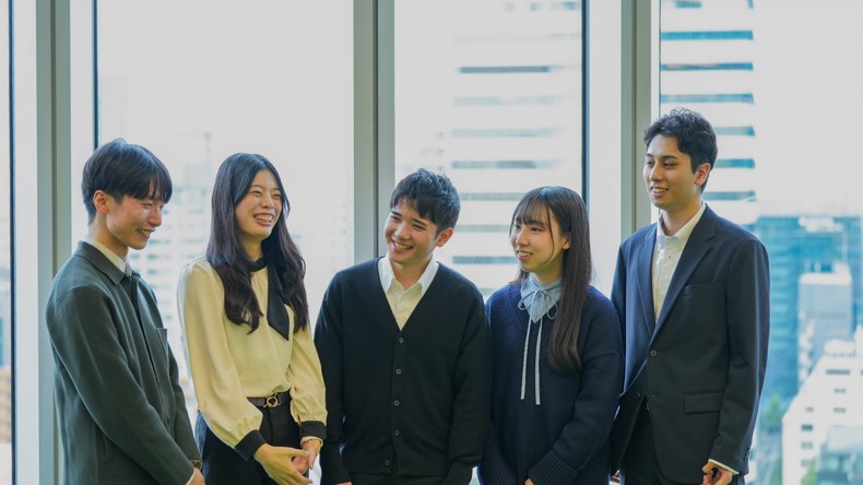 A photo of five people&comma; from left to right&comma; a man&comma; a woman&comma; a man&comma; a woman and a man&comma; smiling and chatting&period; 