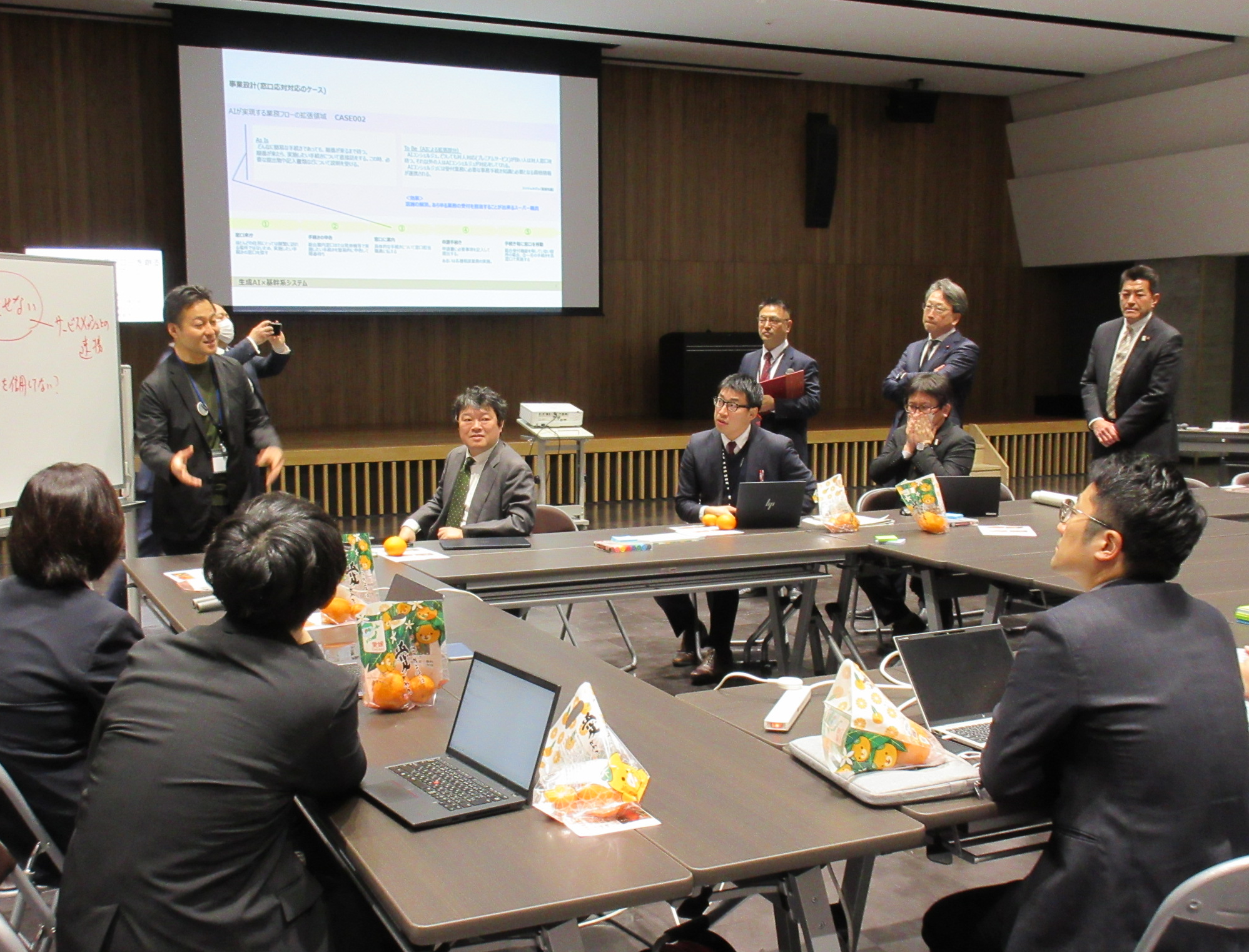 Participants in the AI Ideathon are discussing the situation, and Mr. Taira, Minister for Digital Transformation, is inspecting the situation at a distance.