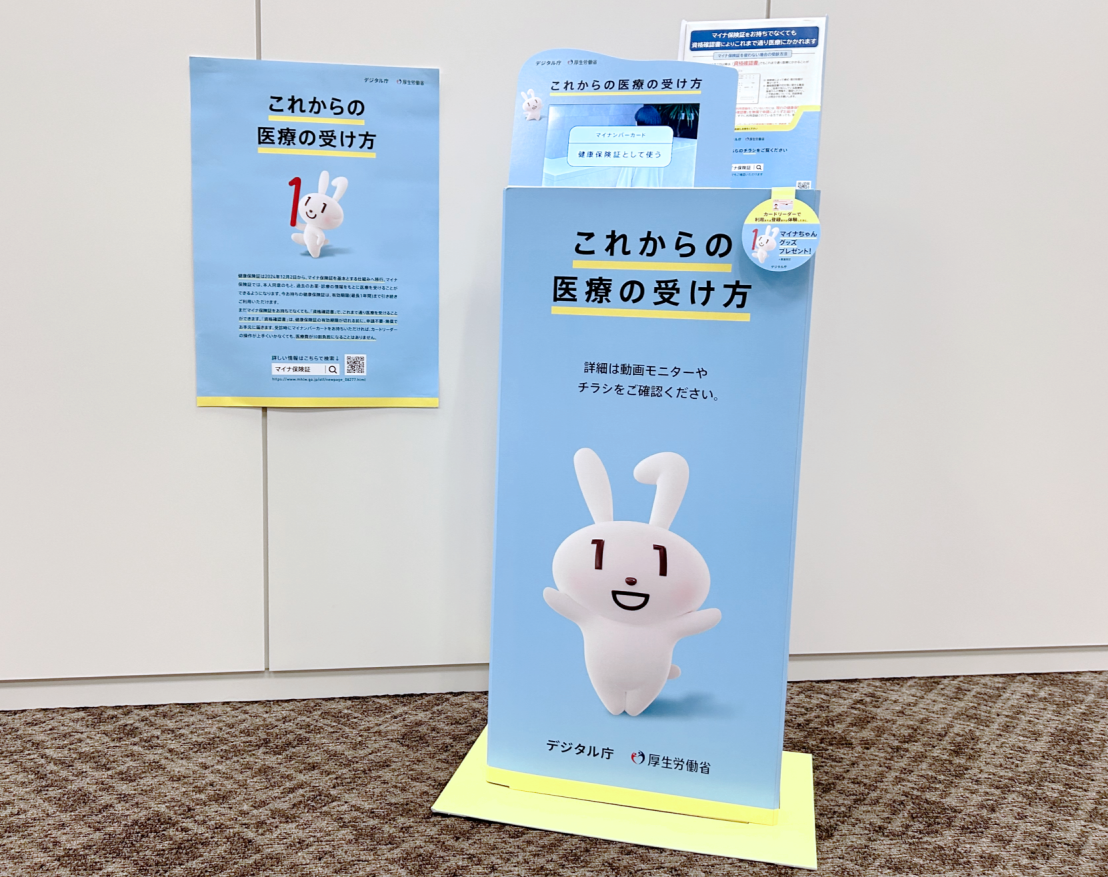 A poster used in the campaign is on the right, and a wagon with a small monitor and a flyer case is on the left. 