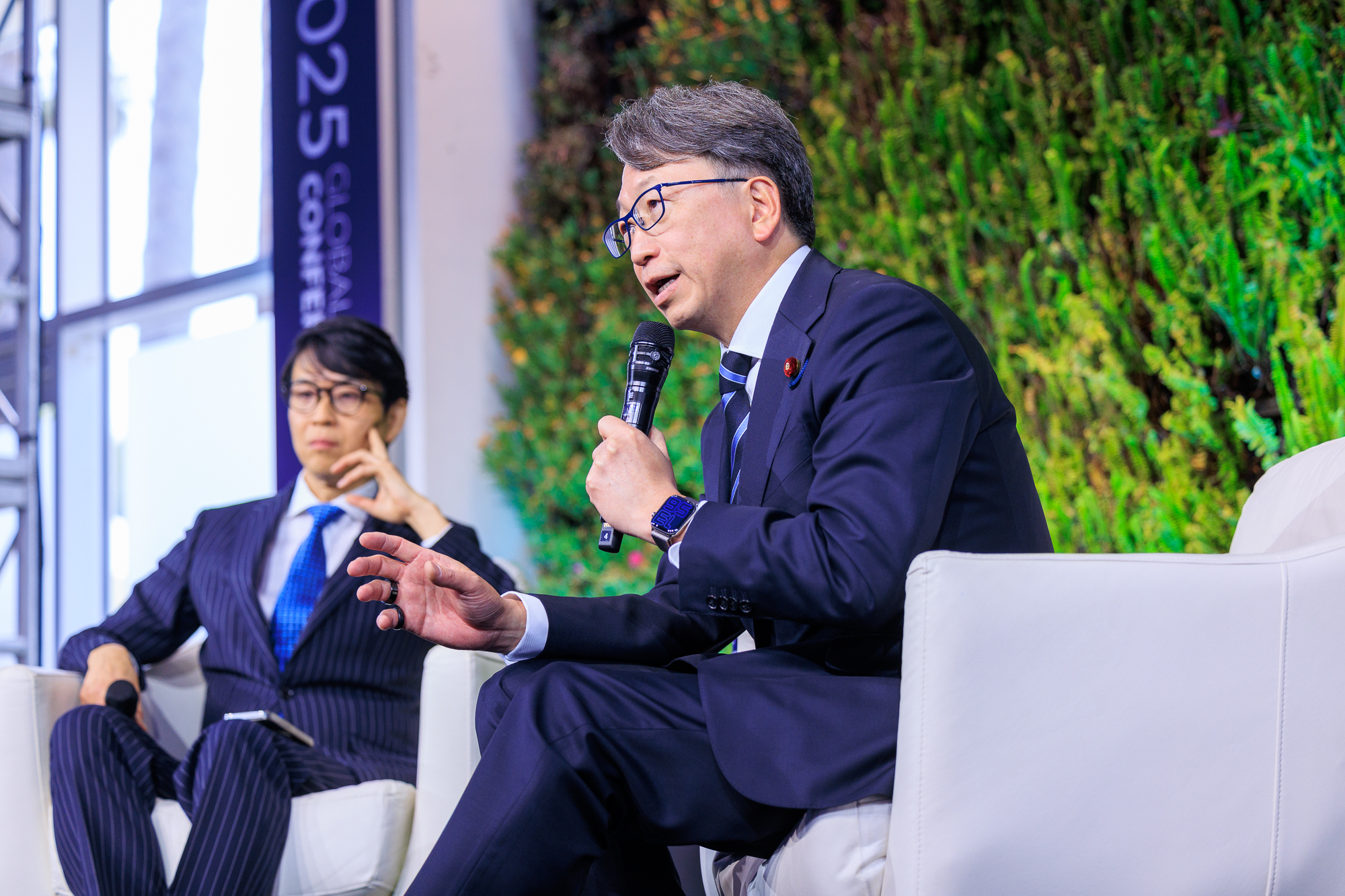 Photo of Digital Minister Taira speaking at the session.  He is on the right and Mizuno CEO on the left.