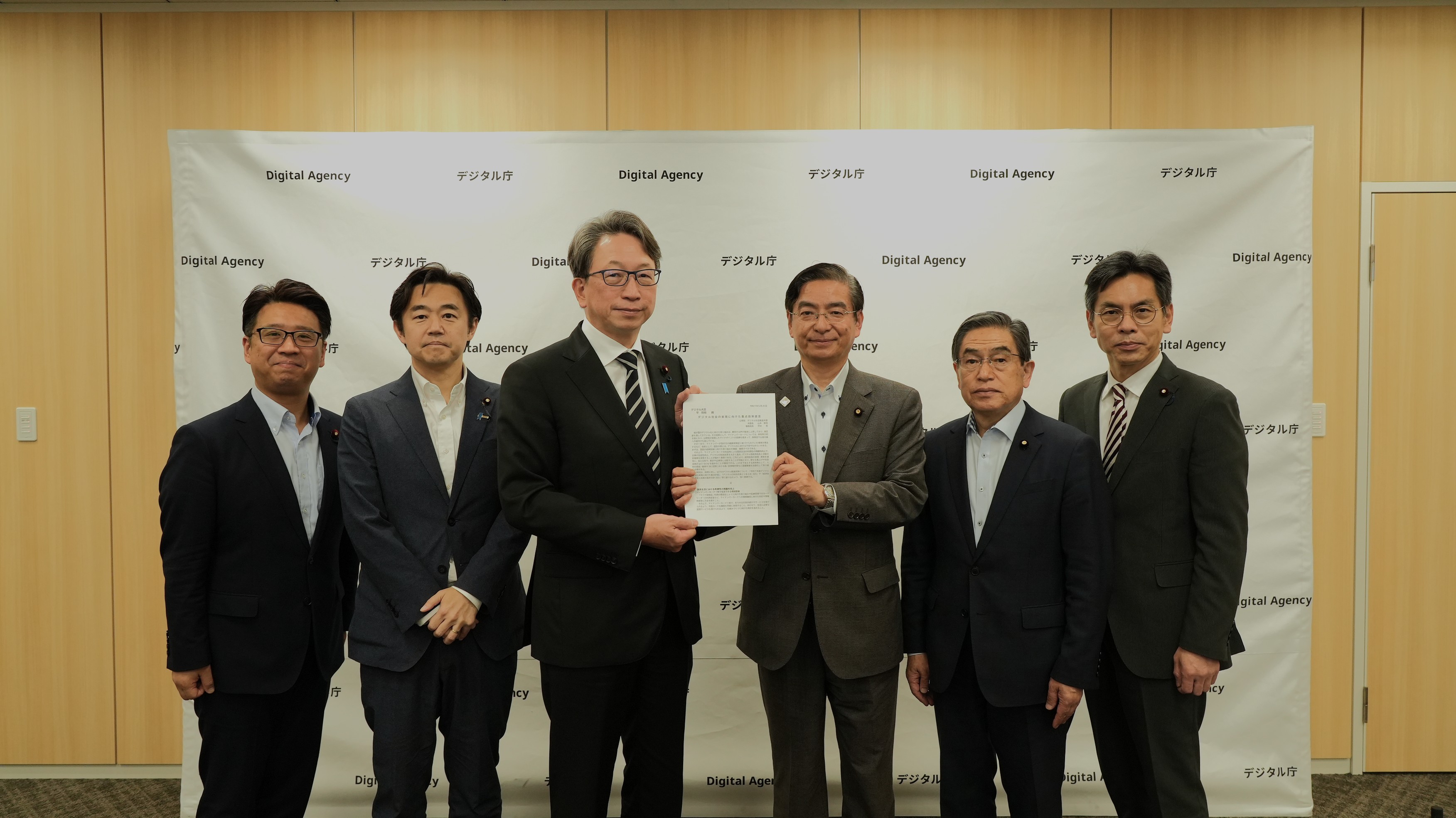 Photo of Mr. Taira, Minister for Digital Transformation, and other members of Digital Agency and Komeito standing side by side