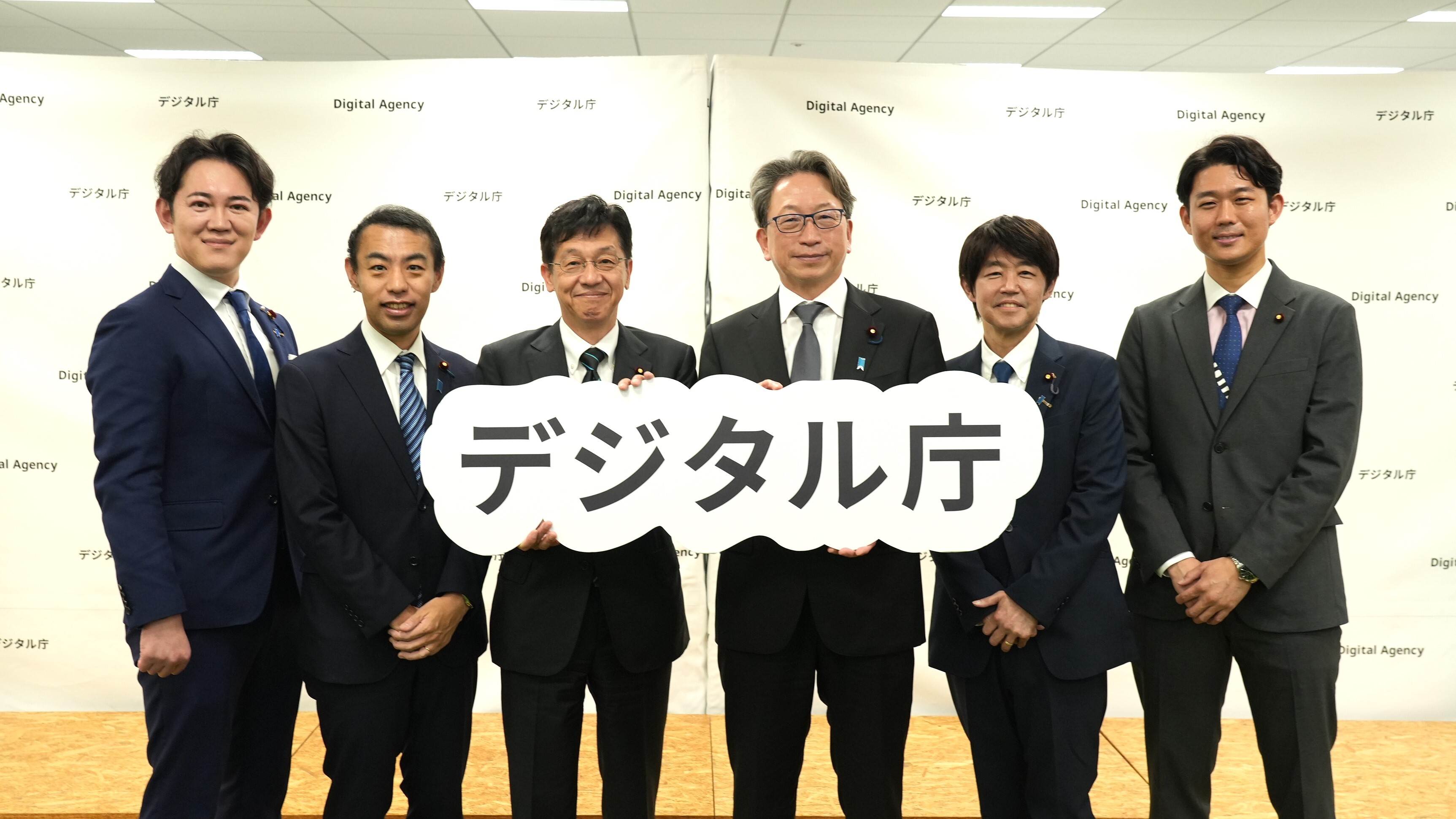 Group photo of former and newly-appointed Ministers, State Ministers, and Parliamentary Vice-Ministers holding the Digital Agency panel, smiling.