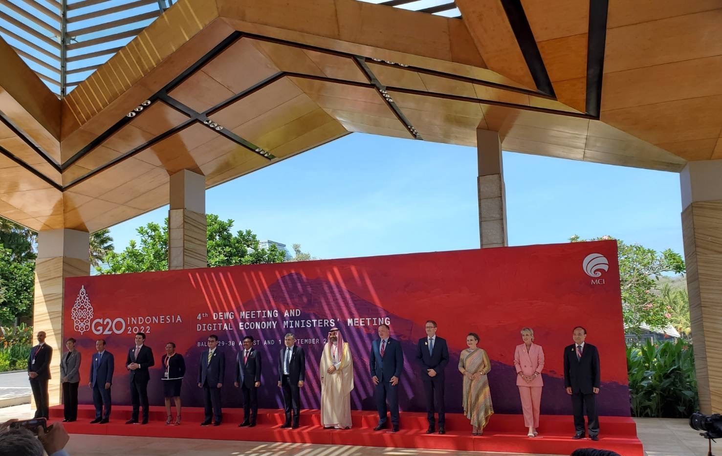Group photo of participants attending the G20 Digital Economy Ministers’ Meeting chaired by Indonesia. Minister Kono is standing sixth from the left. The backdrop is red, featuring the G20 Indonesia logo and lettering in white.