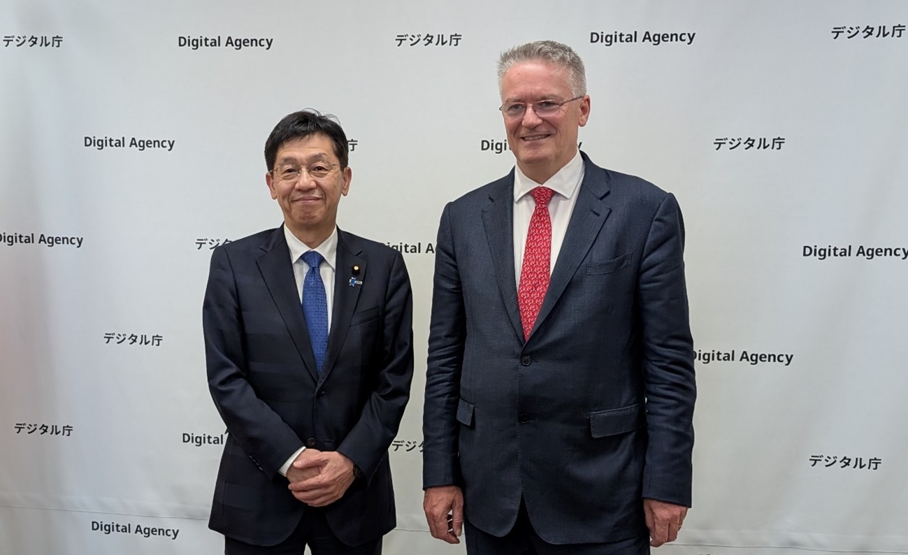 松本デジタル大臣とコーマン経済協力開発機構（OECD）事務総長が笑顔で並んでいる様子。