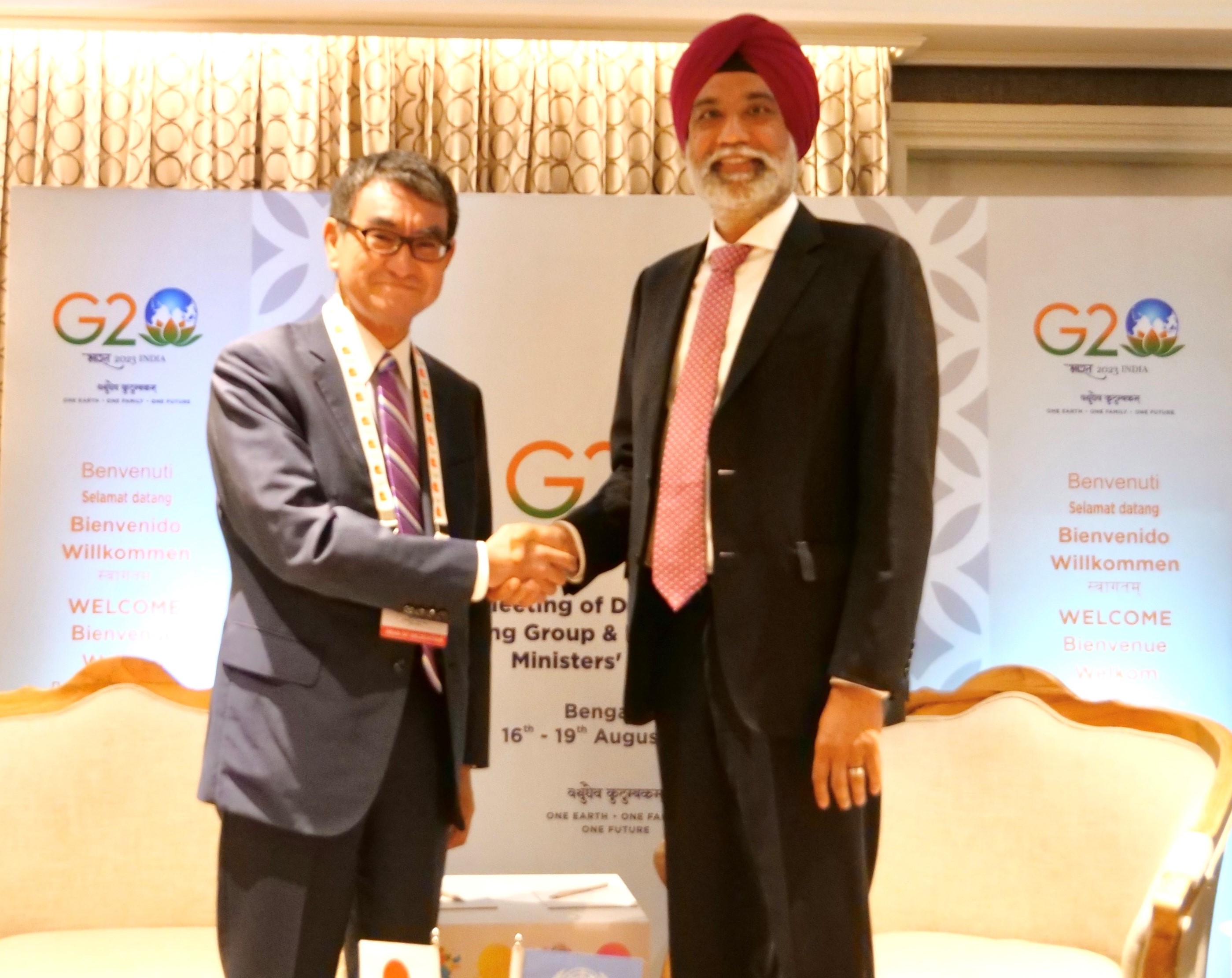 Photo of Mr.Gill of the United Nations (right) and Minister Kono (left) shaking hands.