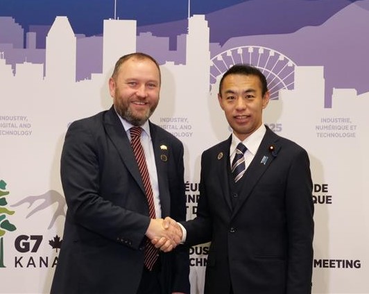英国のマーレー科学・イノベーション・技術省(DSIT)閣外大臣(デジタル政府・データ担当)との会談の様子。左にマーレー科学・イノベーション・技術省閣外大臣、右に今枝デジタル副大臣が立っており、握手をしている。