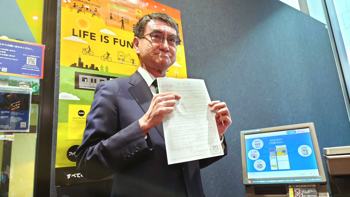 A view of Minister Kono outputting a copy of his residence certificate from a multi-copy machine.