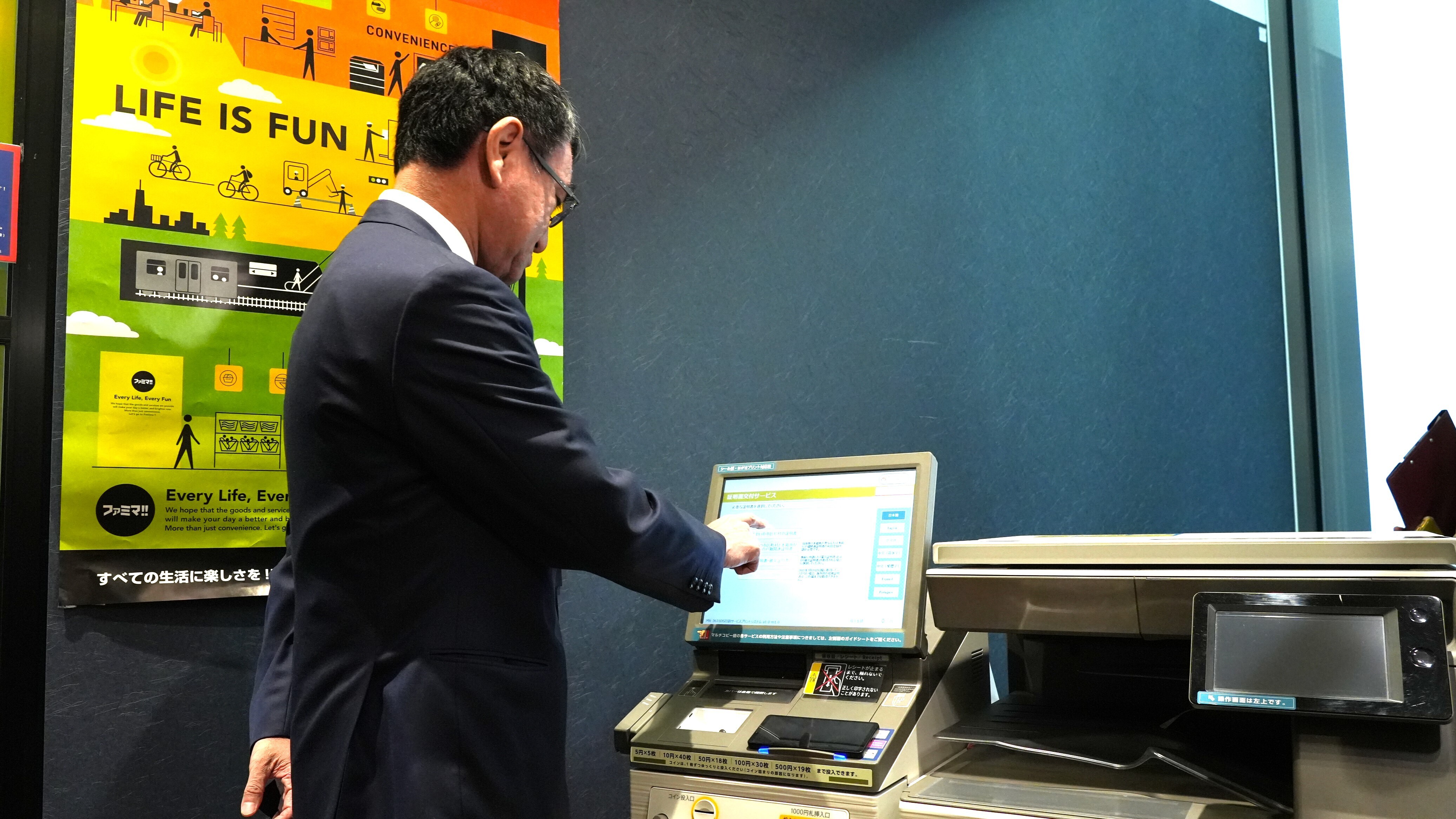 Minister Kono operating a multi-copy machine. 