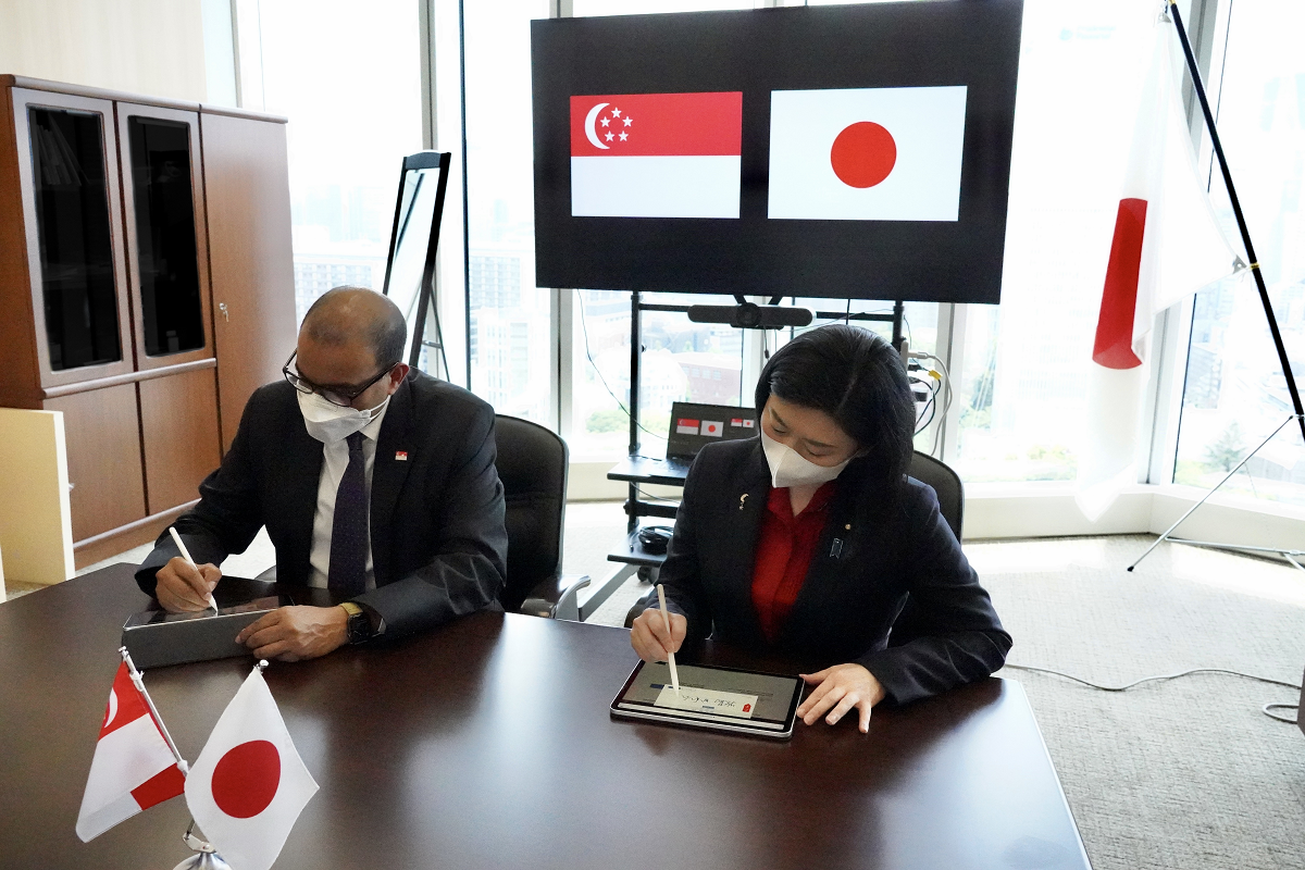 左にシンガポール共和国・ジャニル・プットゥチェリーGovTech担当大臣、右に牧島かれんデジタル大臣が横に並んで座っており、協力覚書(MoC)の署名を行っている